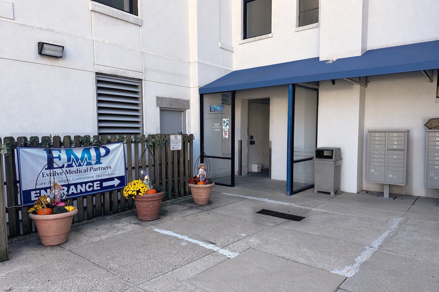 Ground-floor building entrance under the blue awning